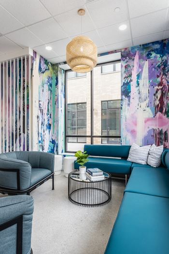 A room with a blue couch and a black chair.